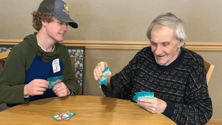 Chelsea Place Memory Care resident with Regis Jesuit High School Student