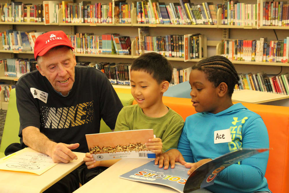 senior resident reading to children